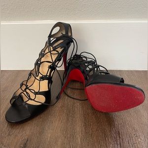 Black leather strap up Christian Louboutin sandals.